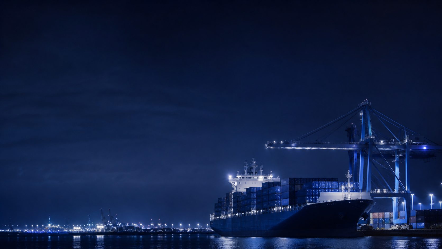Containerschiff bei Nacht in einem europäischen Hafen
